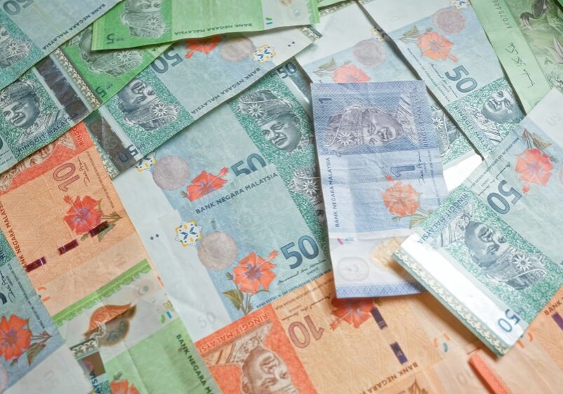 Colorful malaysian ringgit banknotes scattered on a flat surface, highlighting the vibrant currency of malaysia with various denominations visible.