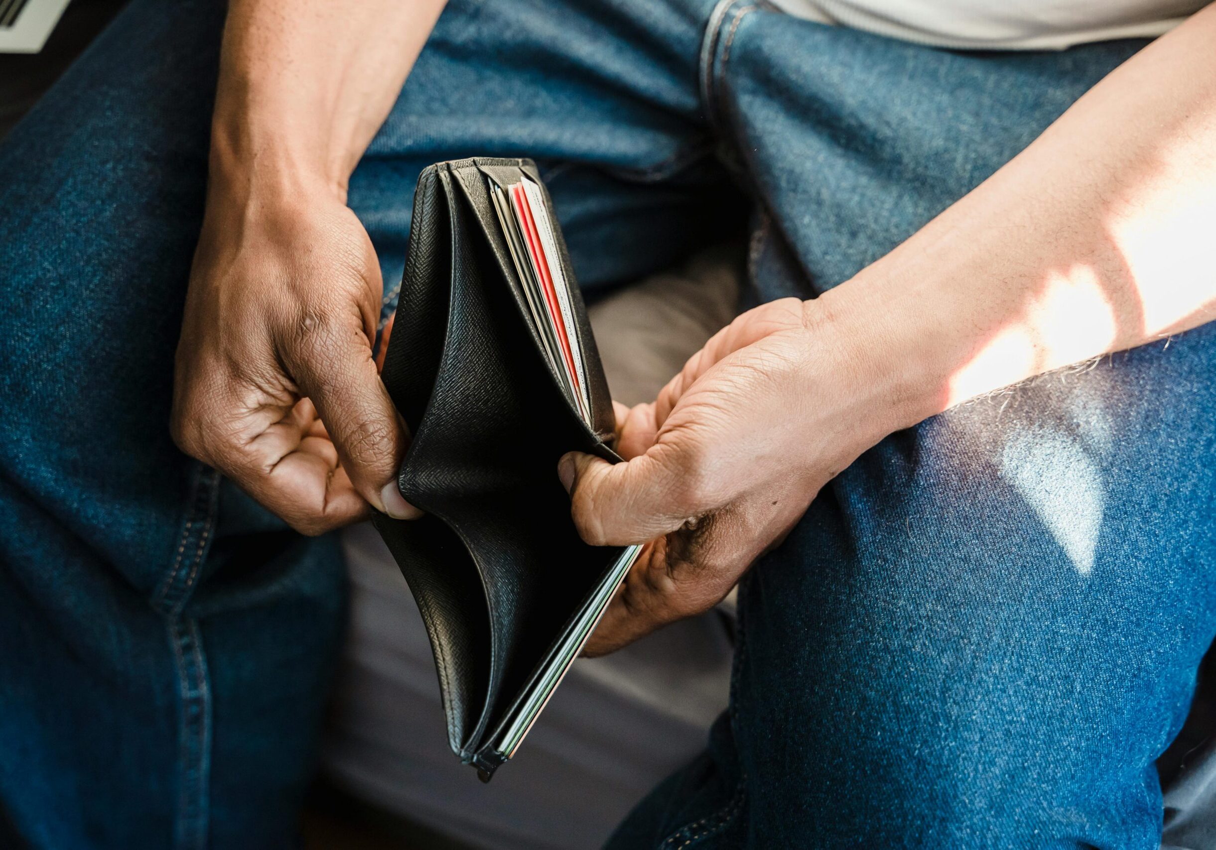 man showing empty wallet, cover image for debt management article